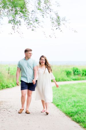 young couple holding hands laughing at Montrose Harbor with their Chicago Sunrise engagement photographer