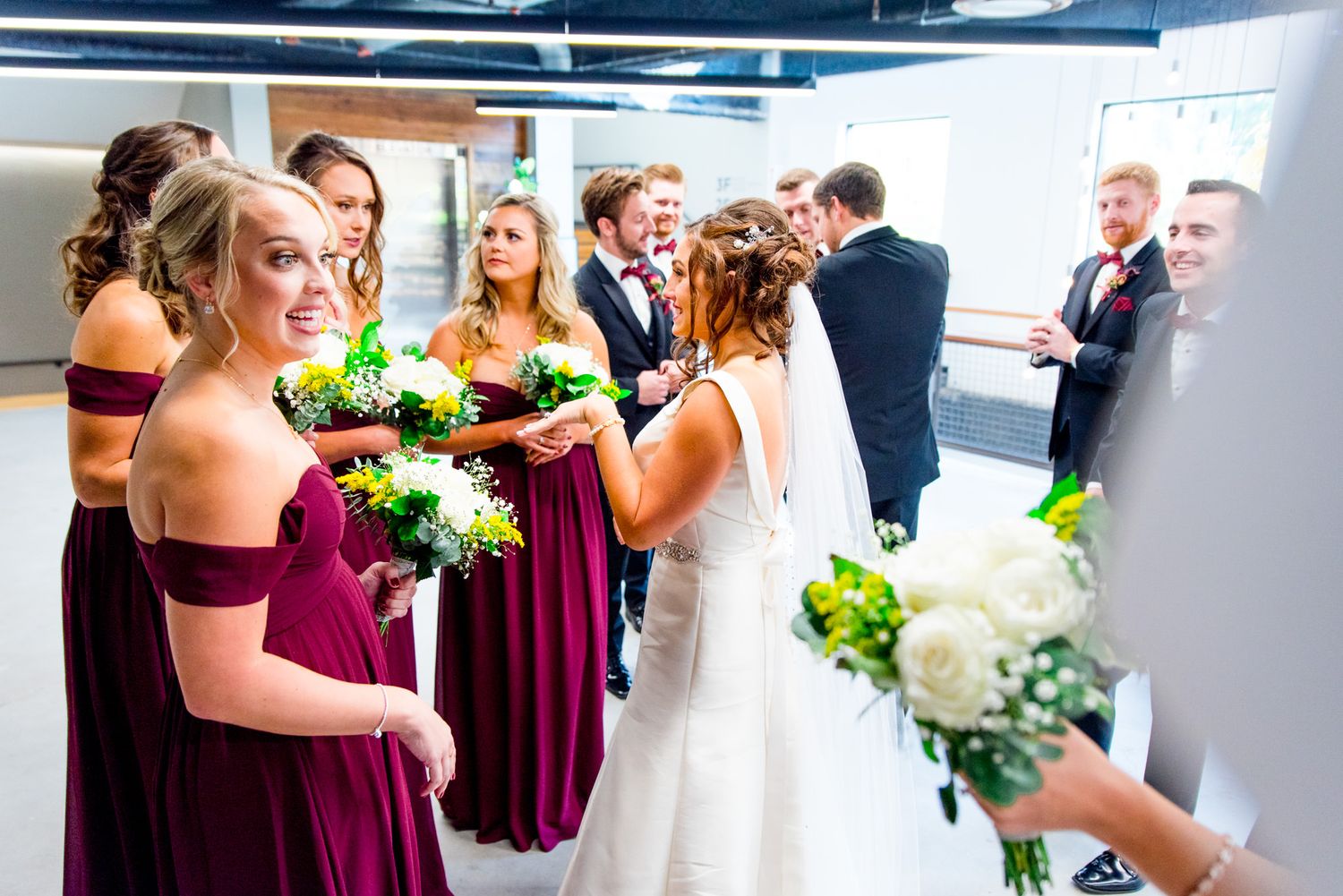 chicago bride greets her bridesmaids in maroon dresses