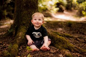 Baby boy photographed sitting against tree in the forest in Melbourne