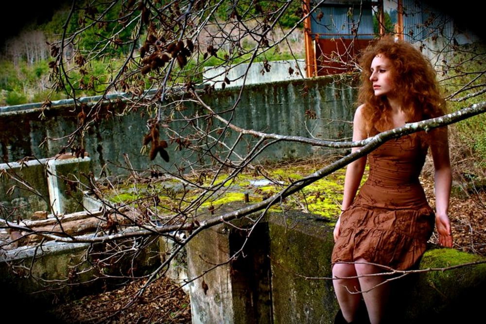 Some of Elise Odom's early photography work depicting a self portrait of Elise in nature sitting upon a cement wall