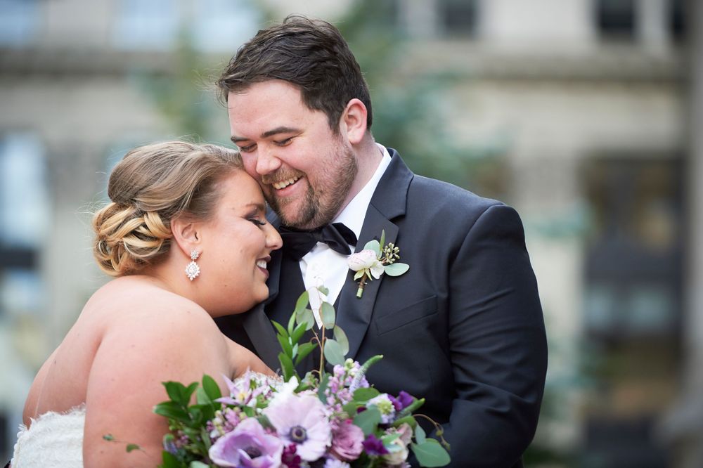 bride and groom laugh and nuzzle and laugh outside philadelphia city hall