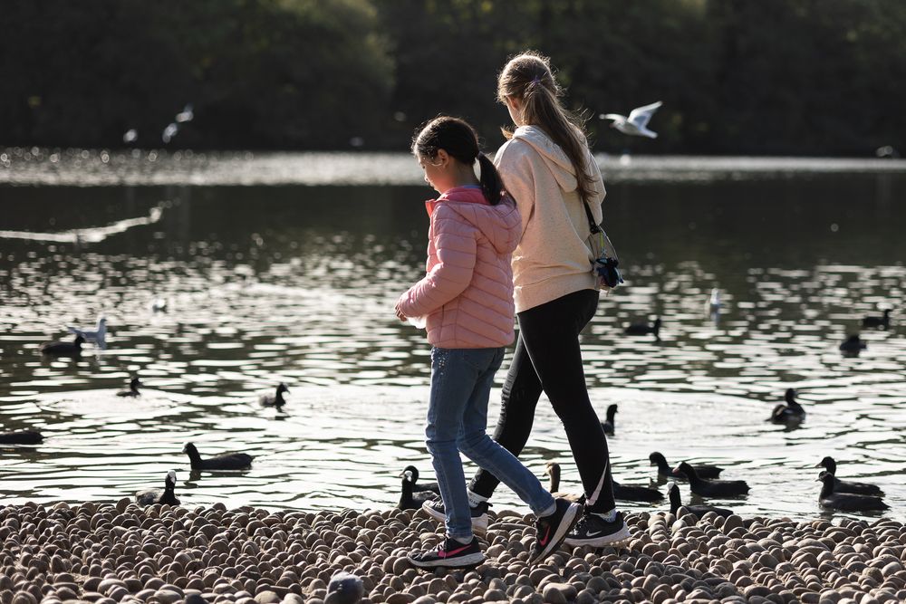 Cousins walking around Lake in Grovelands Park in Enfield