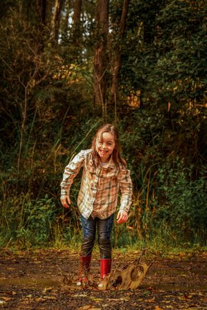 Young child jumping in mud
