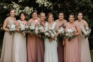 bridesmaids standing with bride in the middle smiling