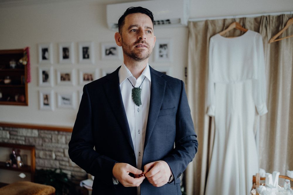 Elegant navy suit and tie ensemble captured in natural window light.