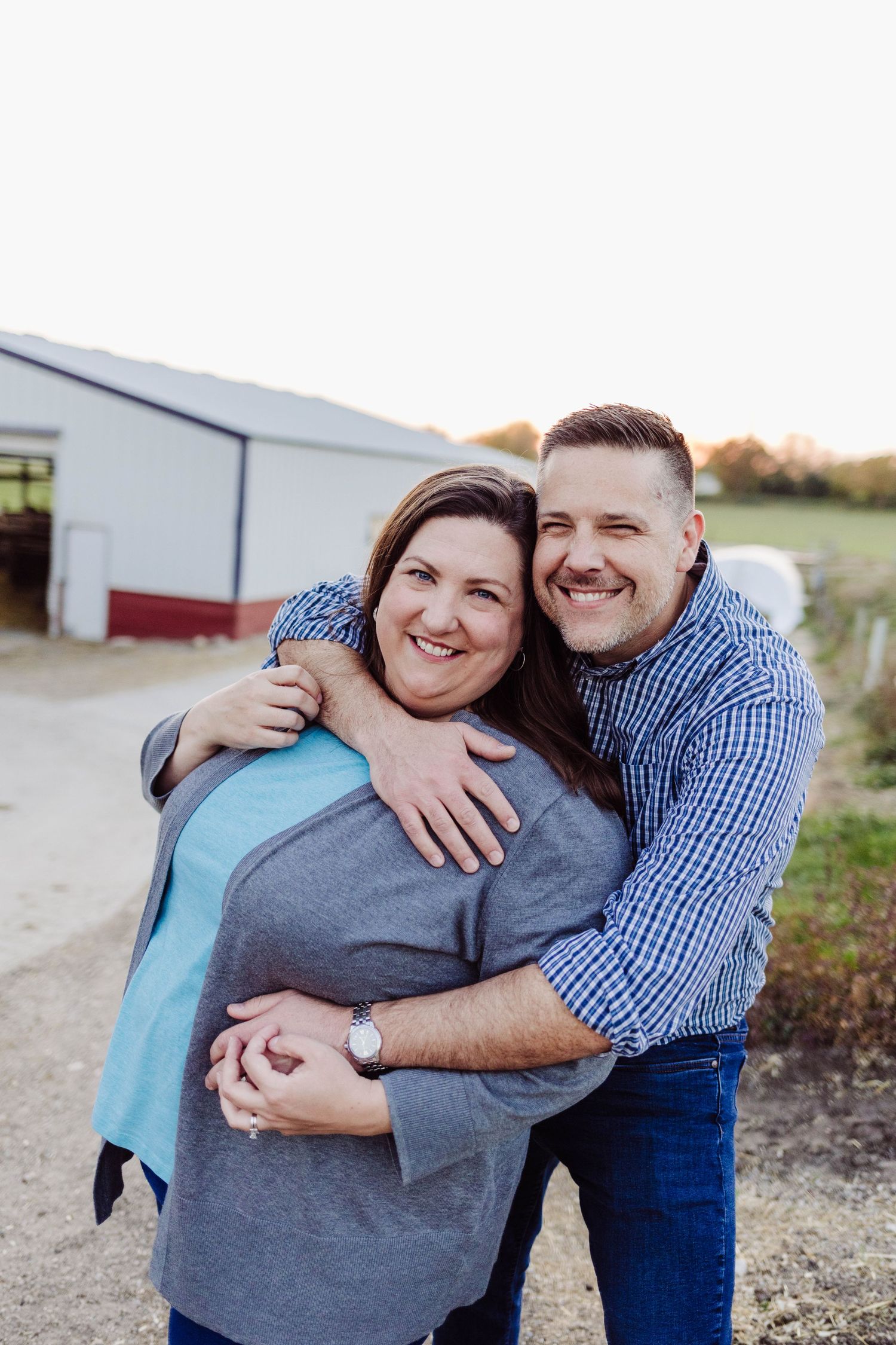 Cute husband and wife taking photos together and snuggling up close wales wisconsin photographer