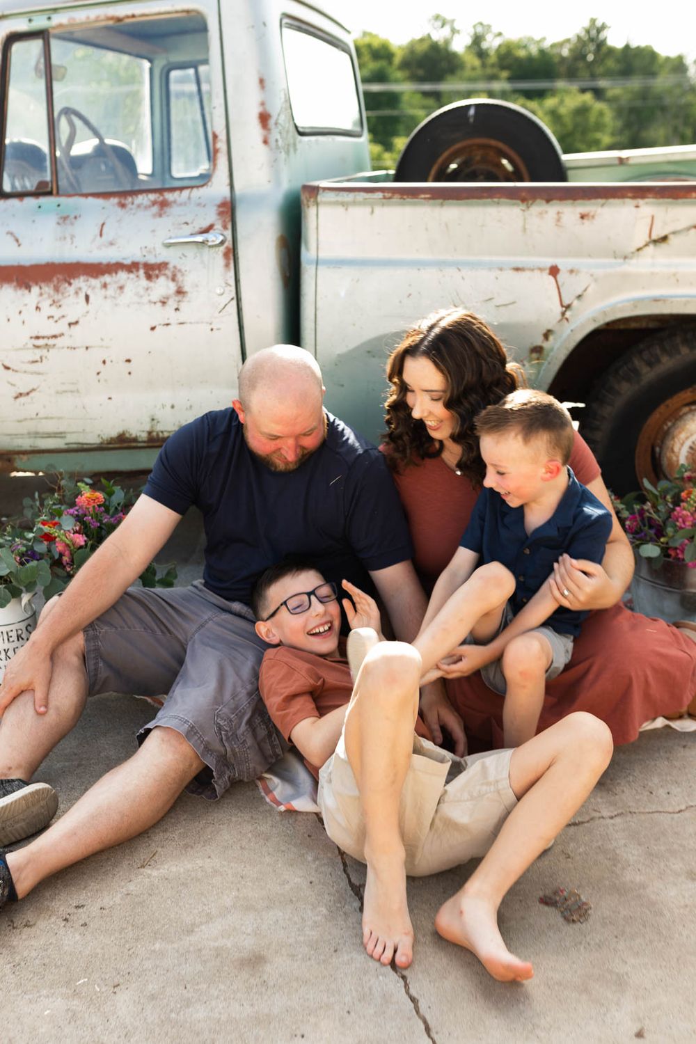 A heartwarming family moment relaxing together near a vintage pickup truck with rustic charm.