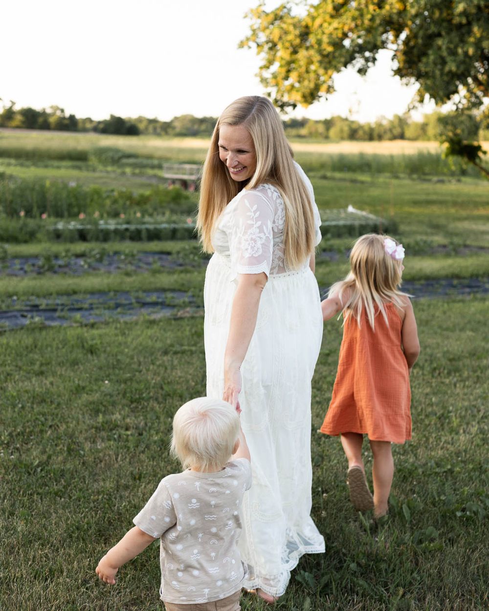 Family walking together in a scenic field during golden hour.