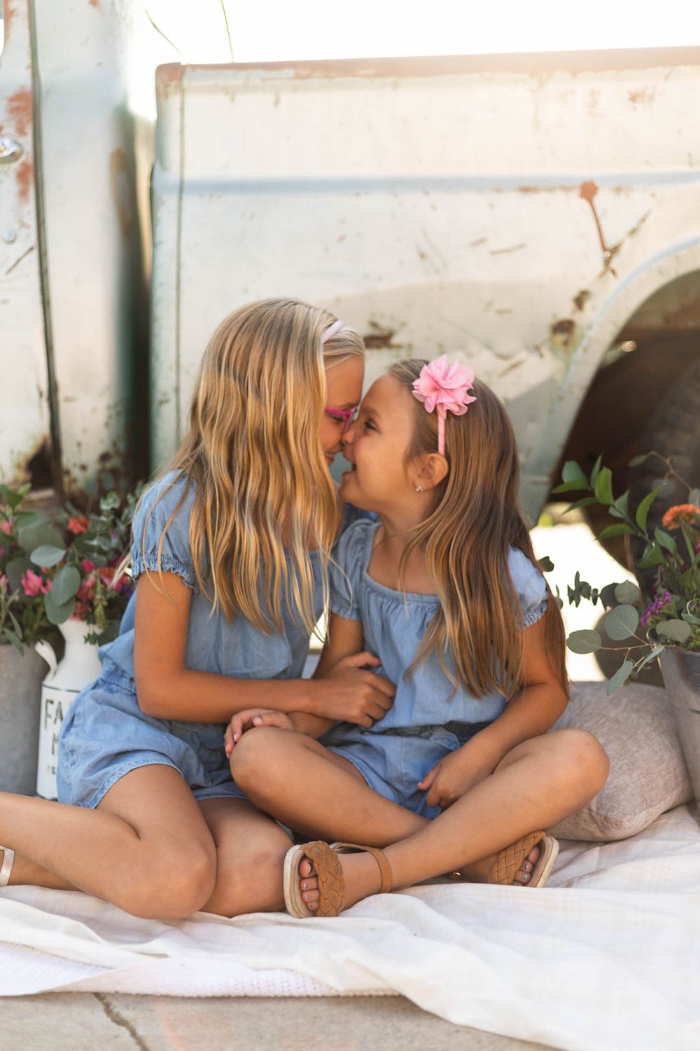 Two children in matching denim outfits share a sweet moment together.