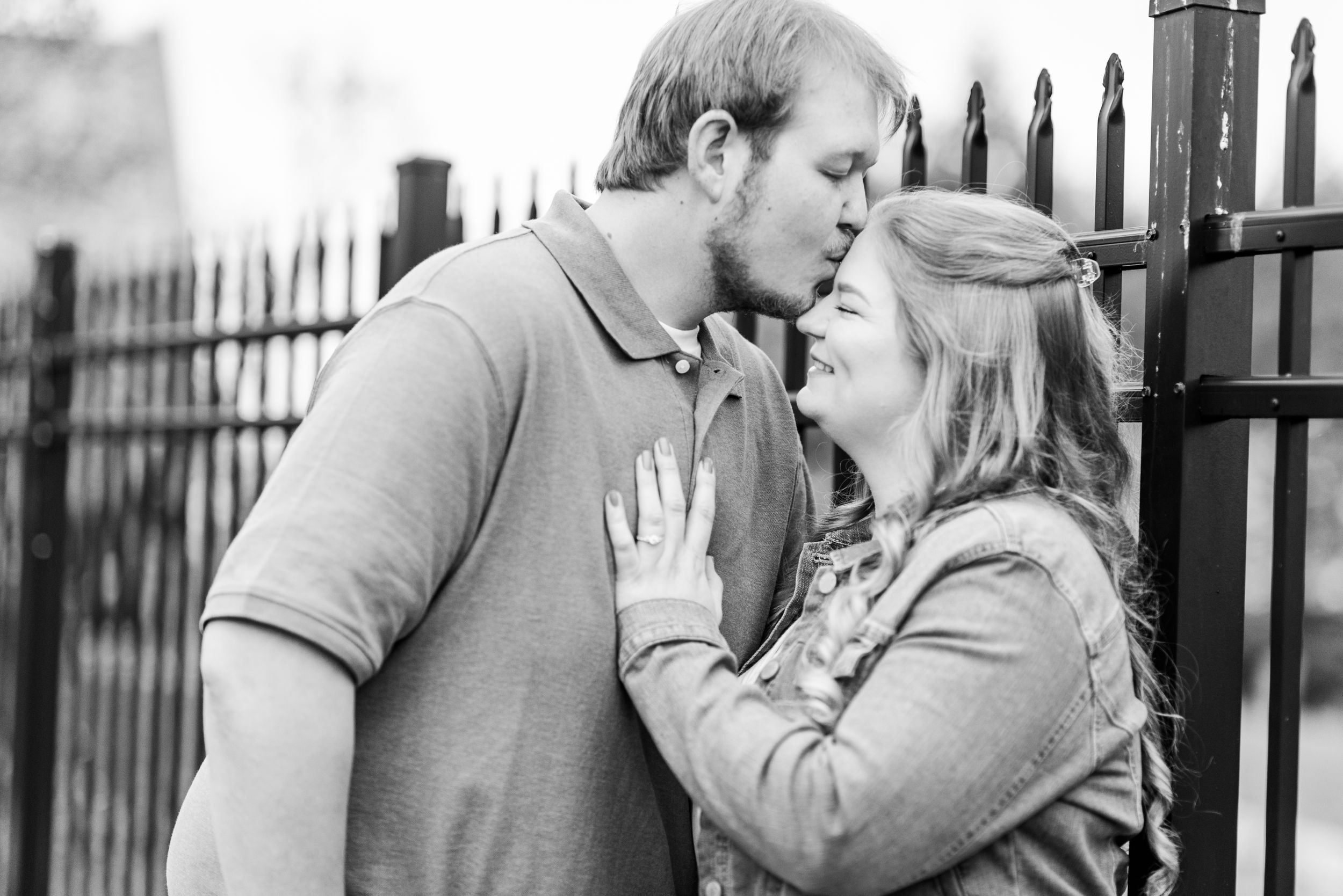 Spring engagement session with couple standing in front of fence at Hartwood Acres in Pittsburgh, Pennsylvania