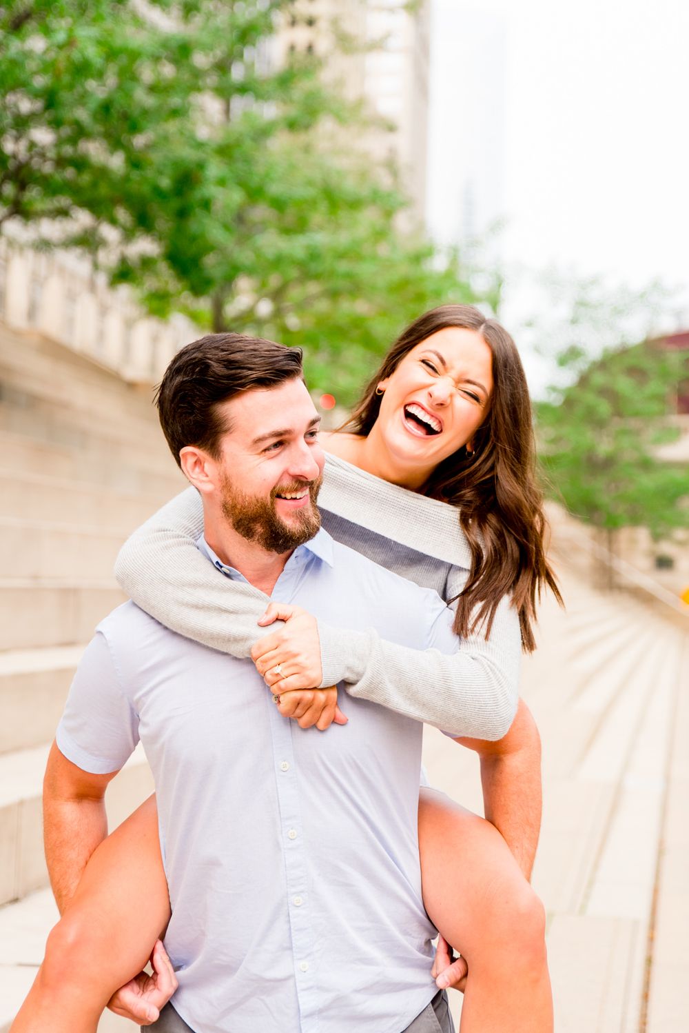 woman with brown hair laughing with fiance at Chicago Riverwalk sunrise engagement pictures