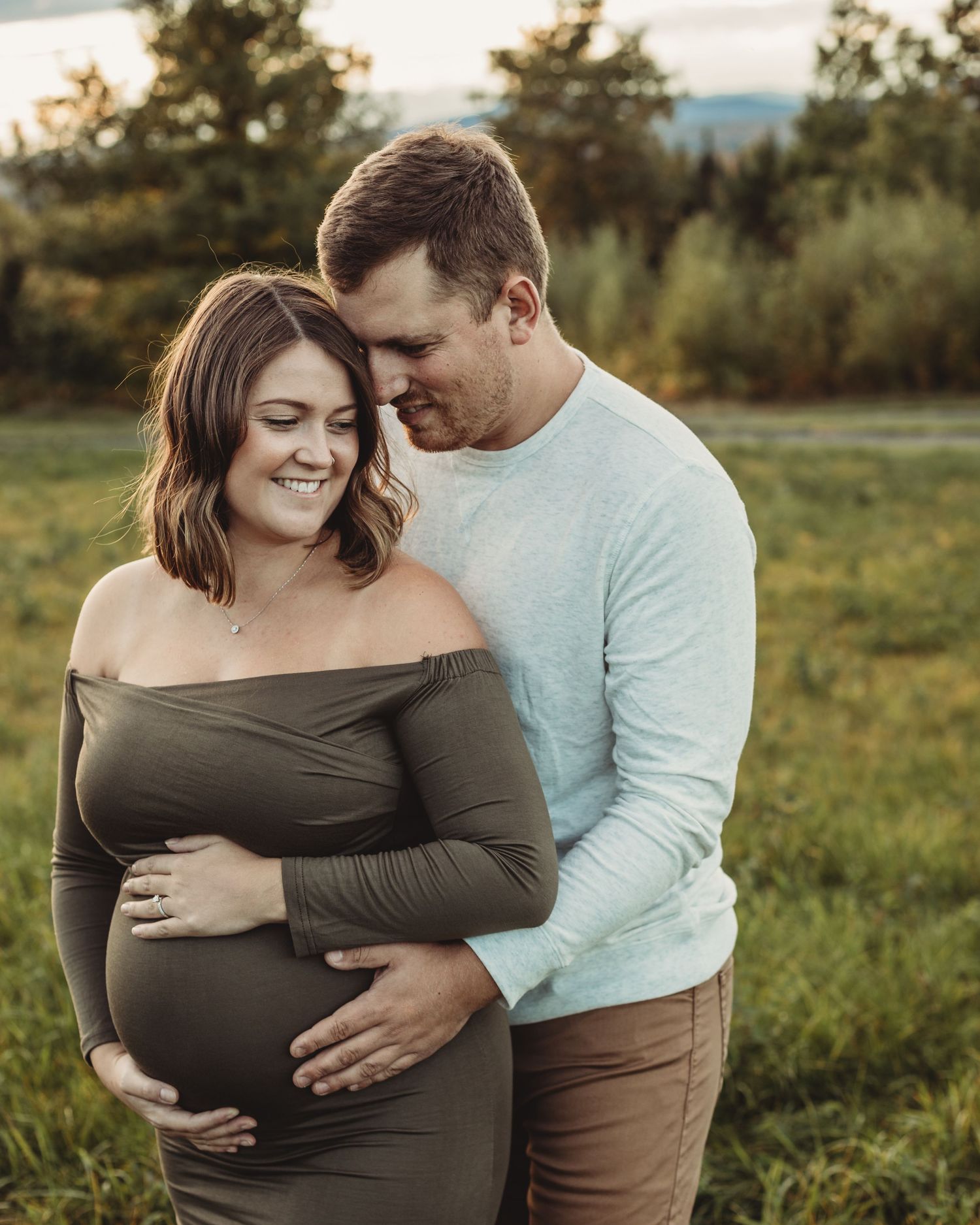 Professional outdoor maternity photo mother in green dress with father
