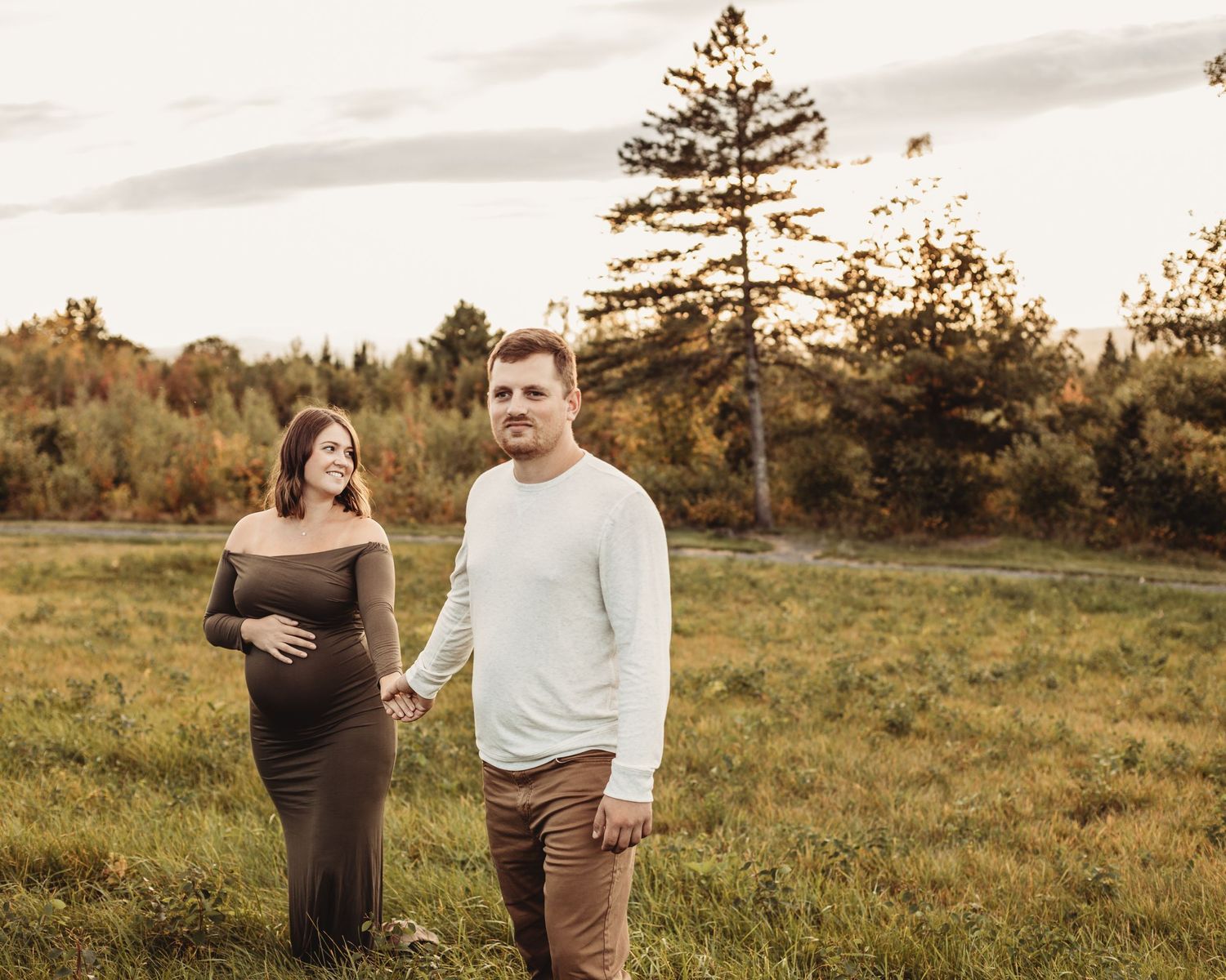 Professional outdoor maternity photo mother in green dress with father