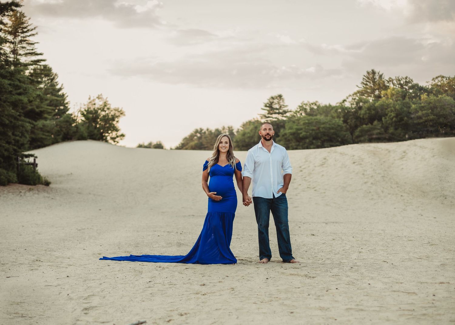 Professional outdoor beach maternity photo mother in blue dress with father