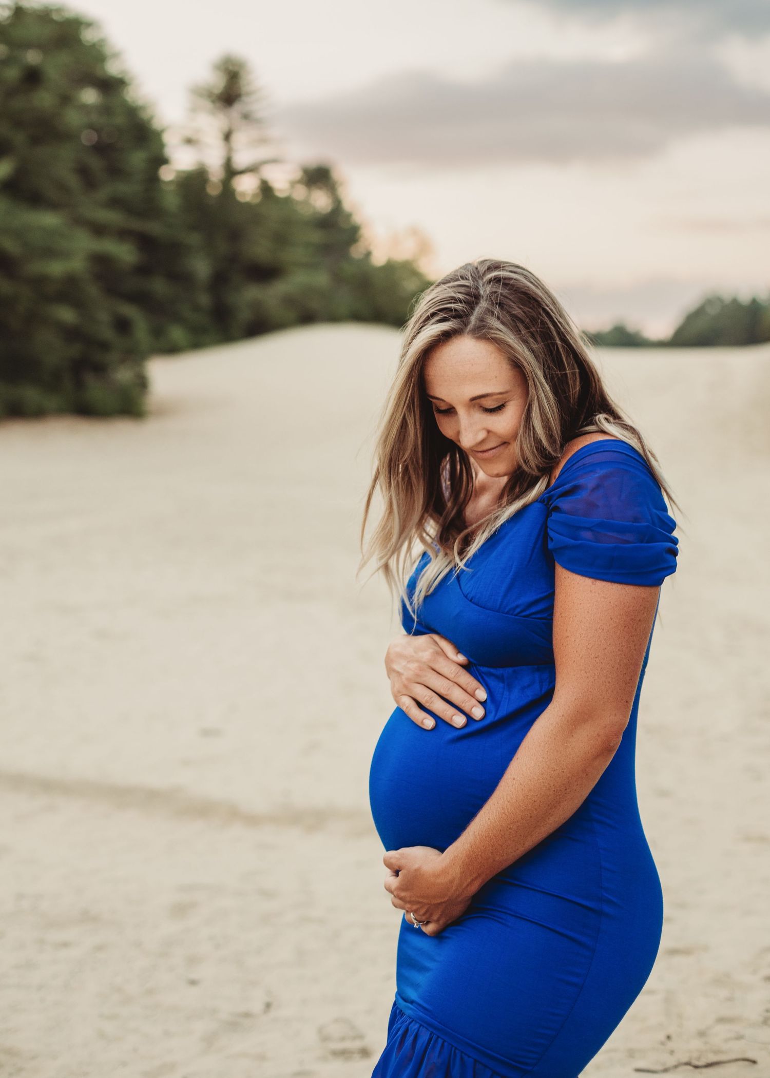 Professional outdoor beach maternity photo mother in blue dress