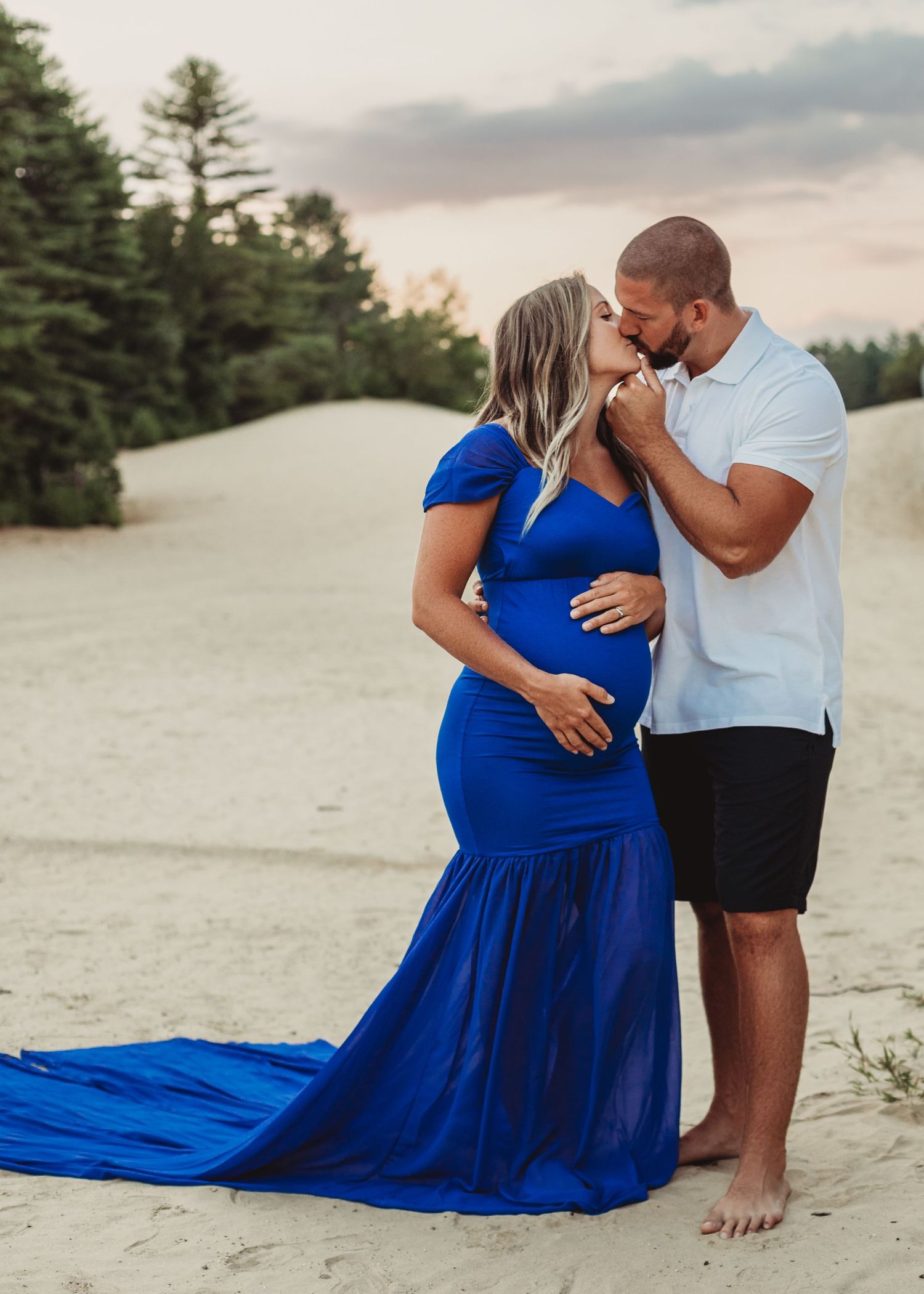 Professional outdoor beach maternity photo mother in blue dress with father