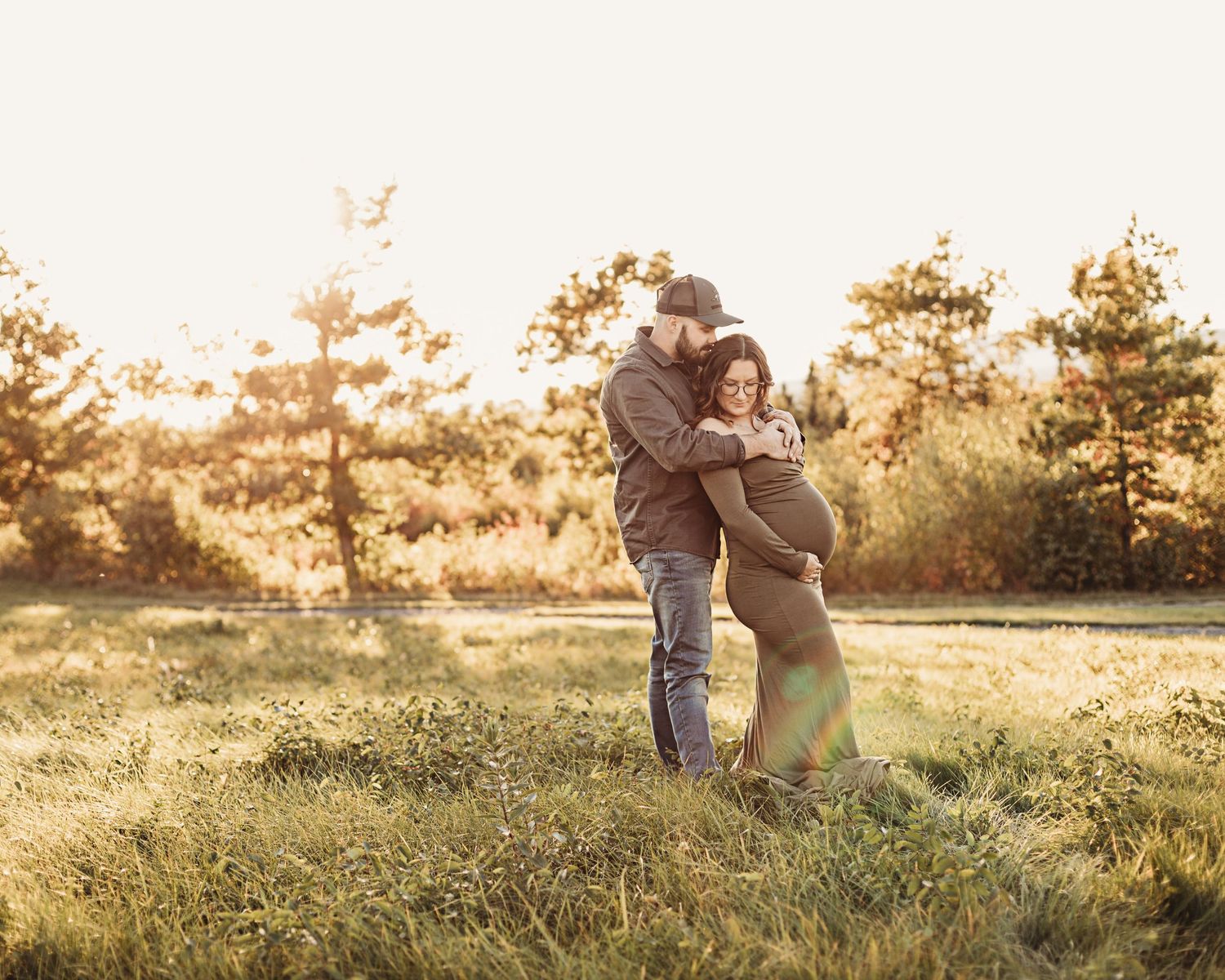 Professional outdoor maternity photo mother in green dress with father