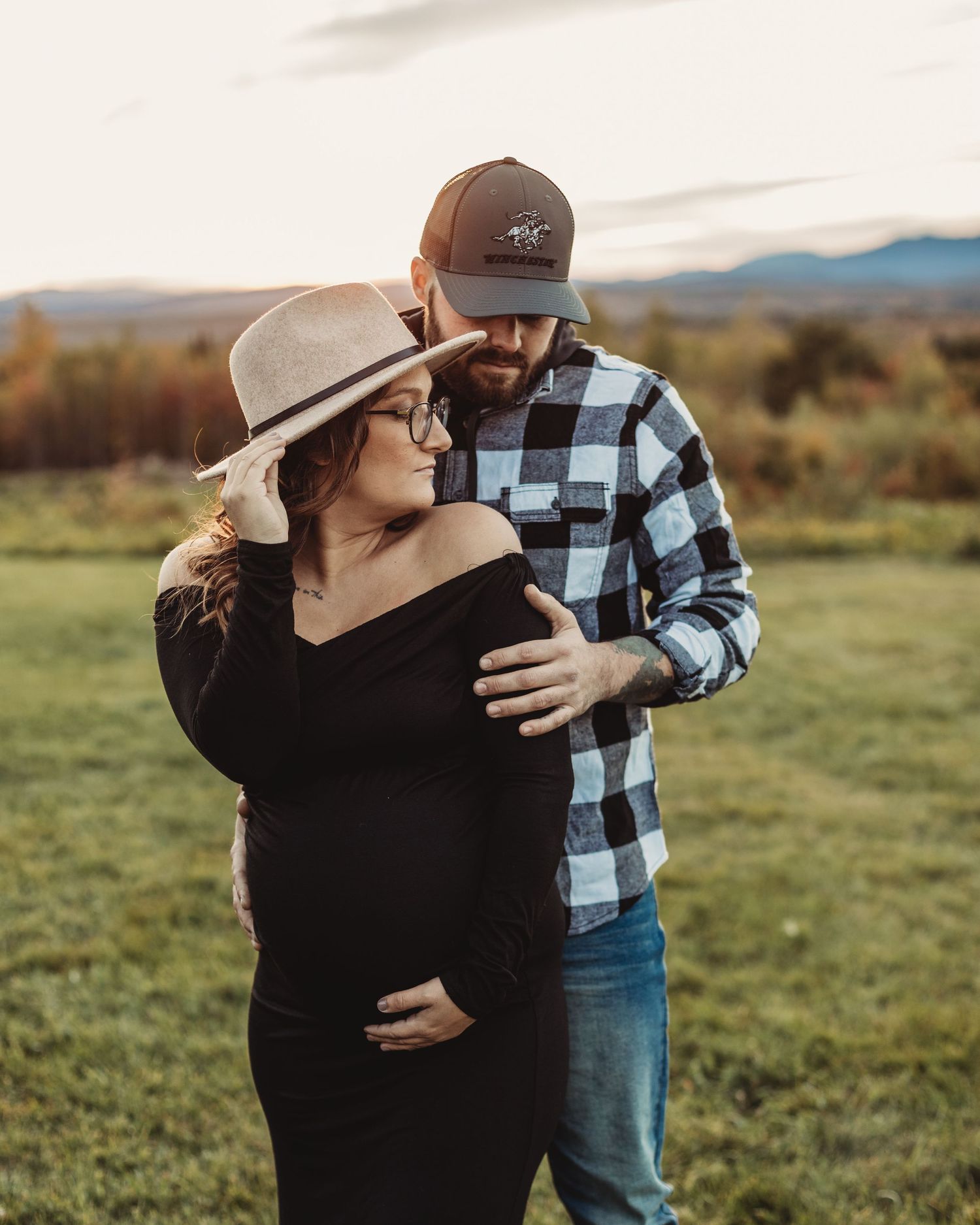 Professional outdoor maternity photo mother in black dress with father