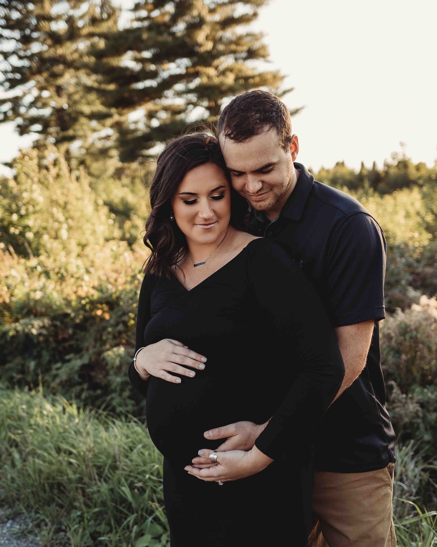 Professional outdoor beach maternity photo mother in black dress with father