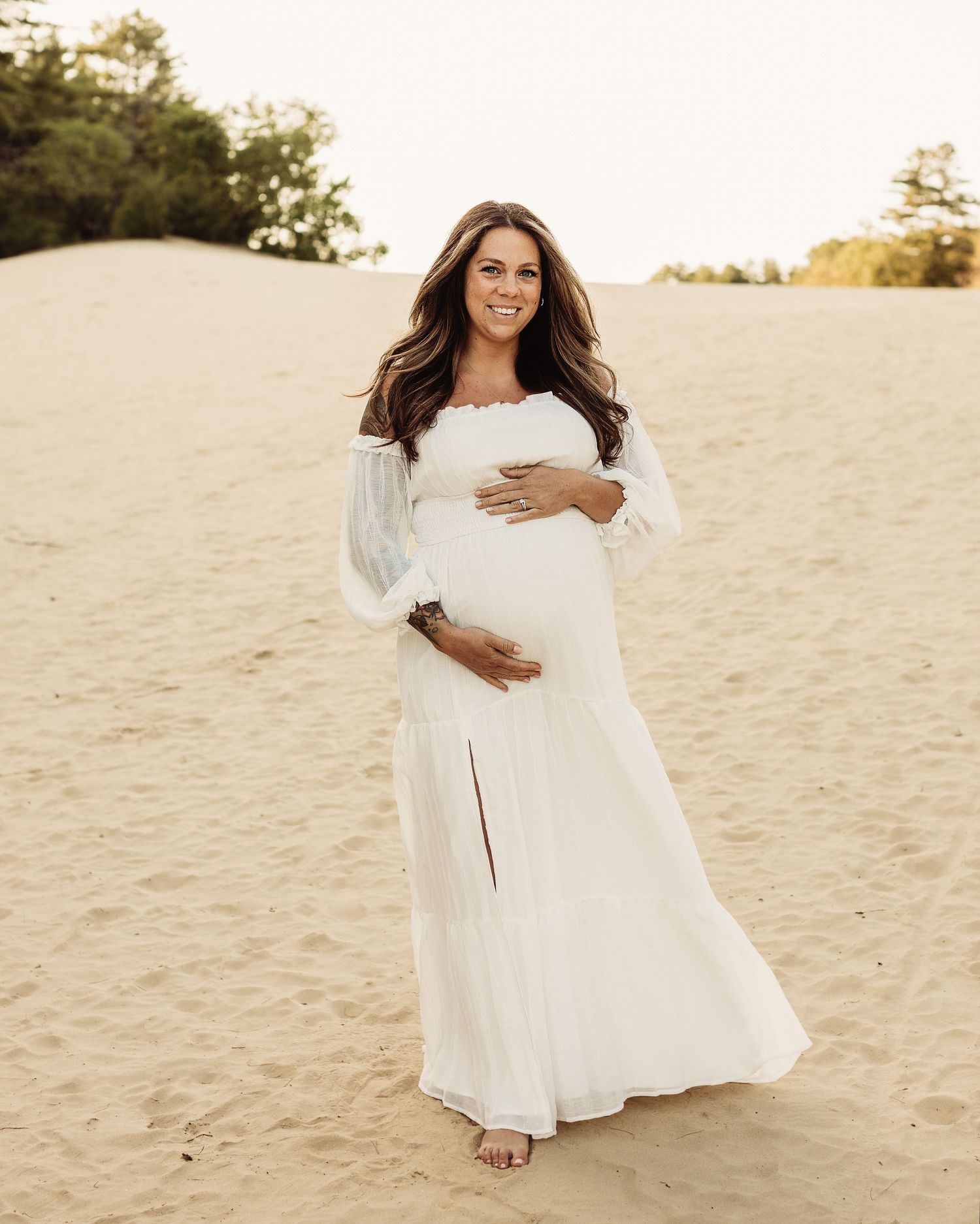 Professional photo of a pregnant mother dressed in white on the beach