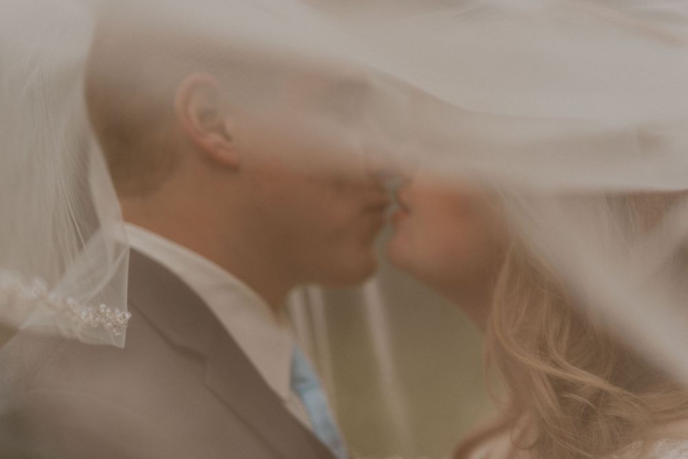 Photo by Kelsie Burke Photography of the bride and groom from under their veil