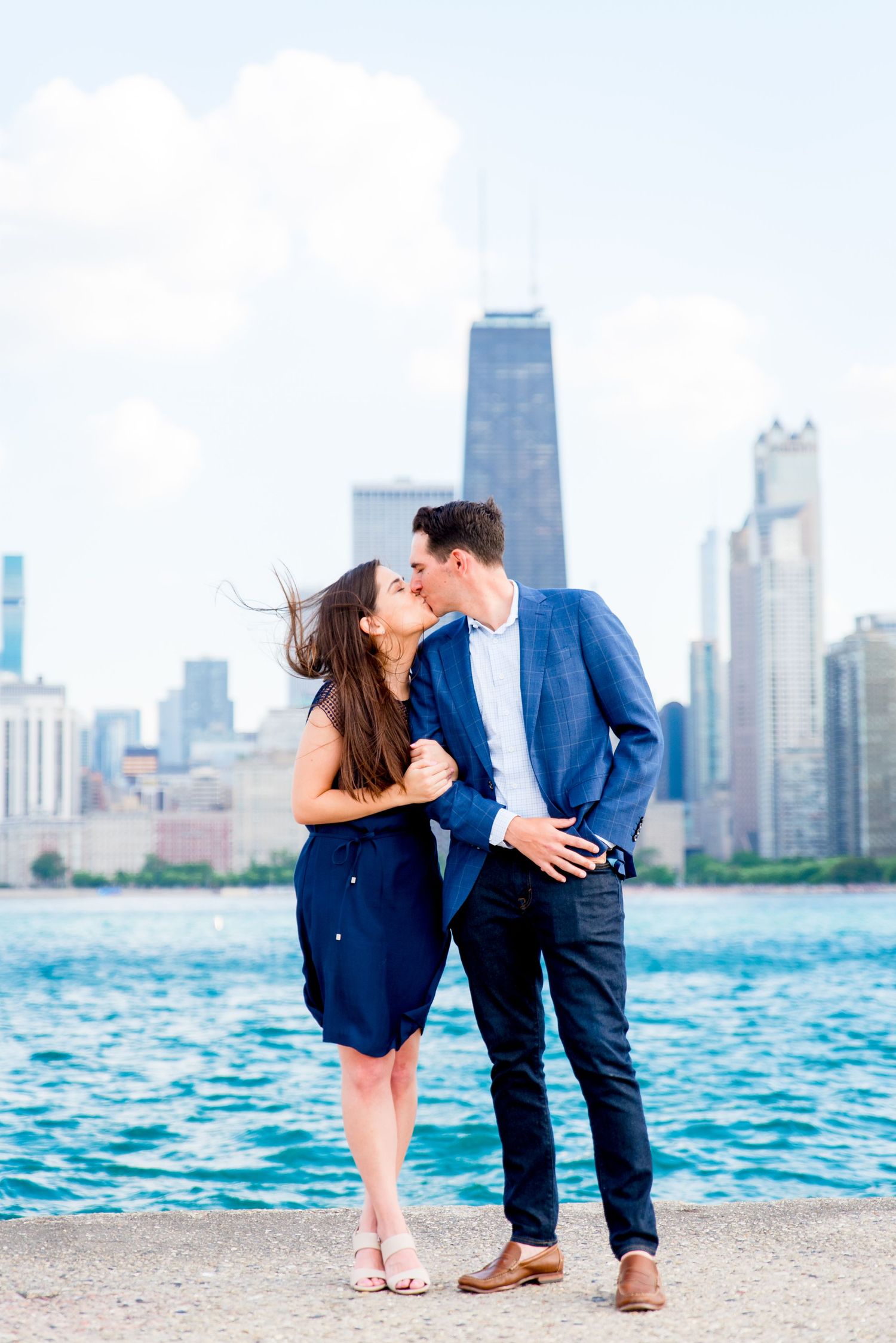 man and woman kissing in front of Hancock tower after North Avenue Beach proposal