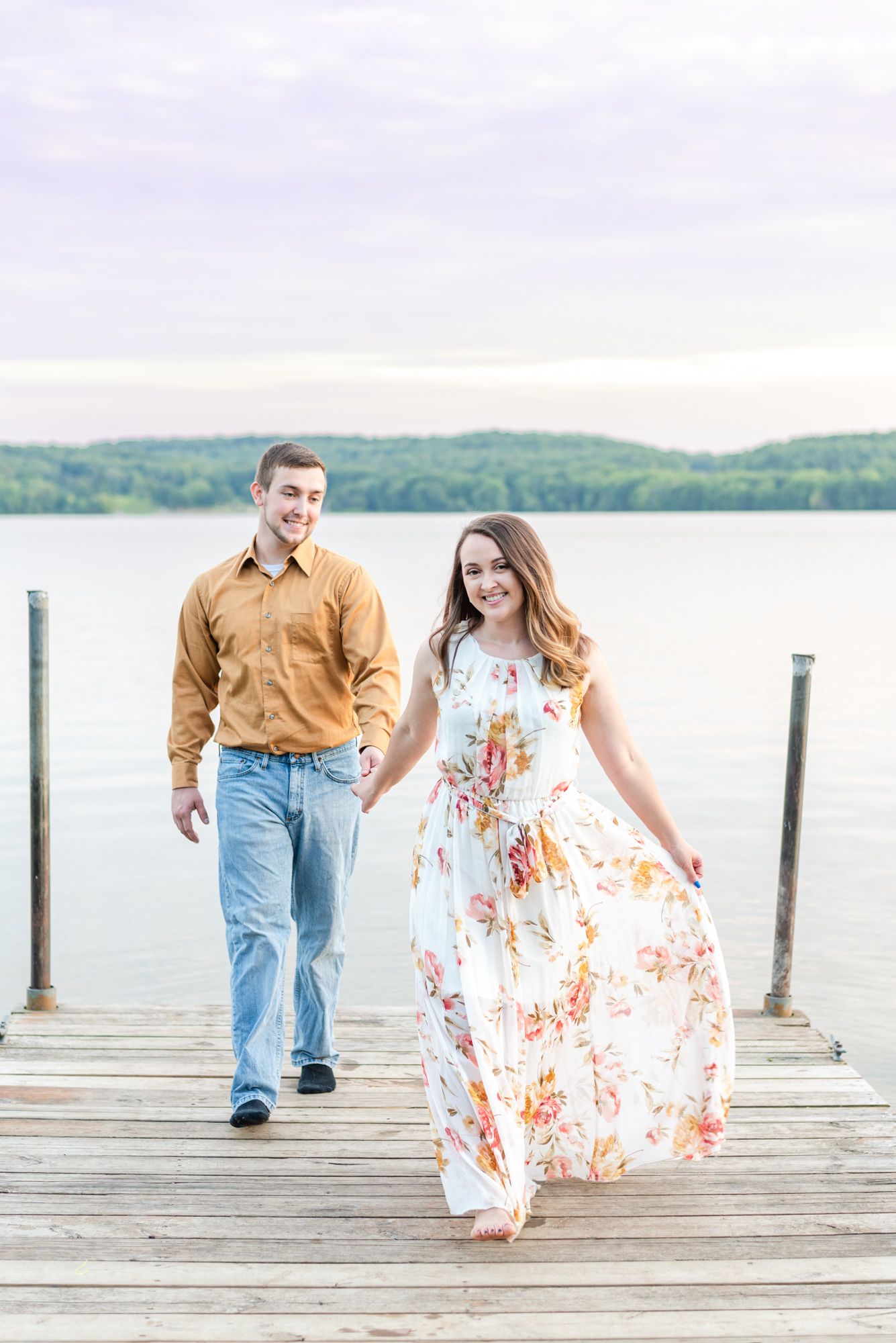 Couple walking for engagement on dock of Lake Arthur at Moraine State Park in Pennsylvania