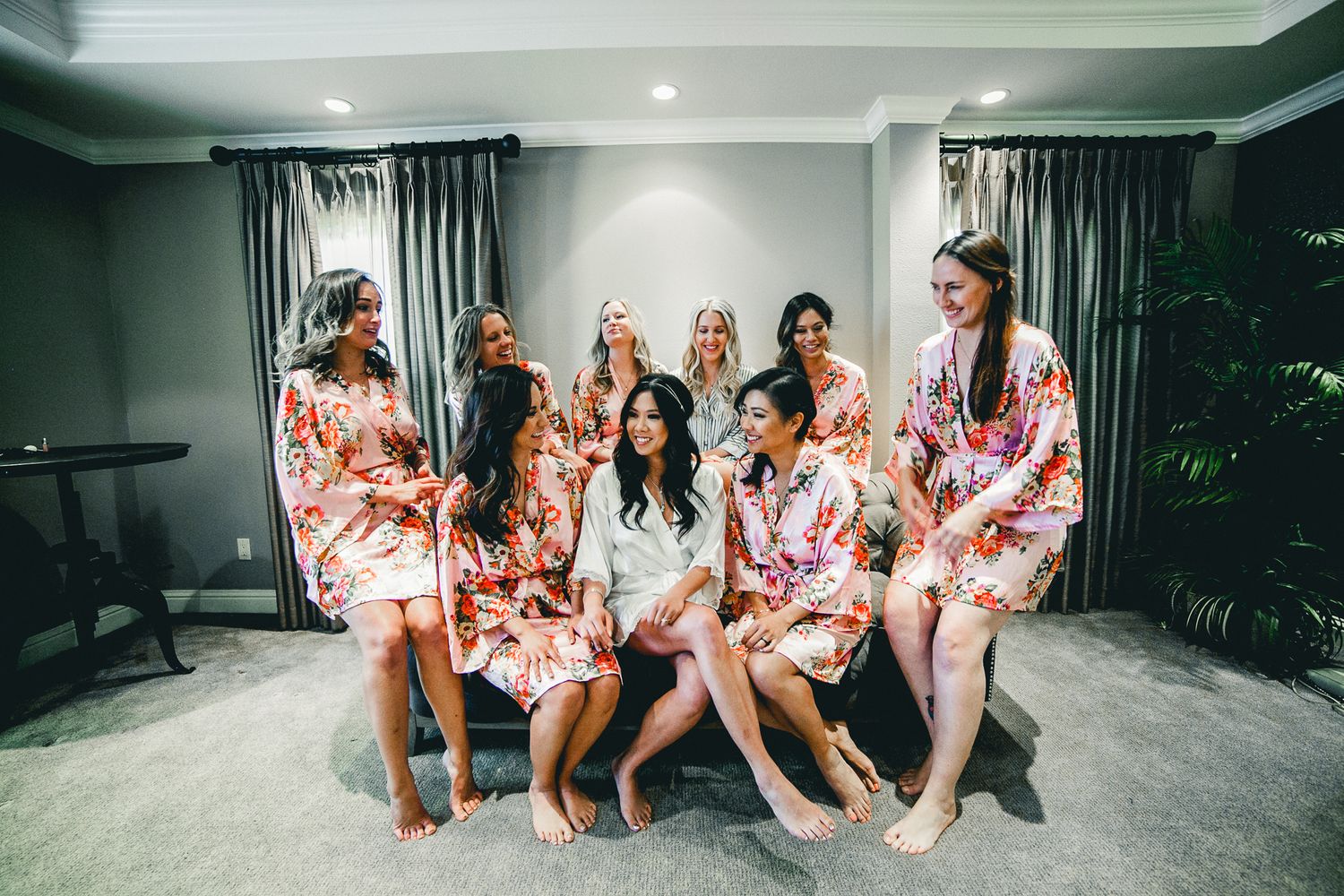 bridal party sitting on couch with bride in robes