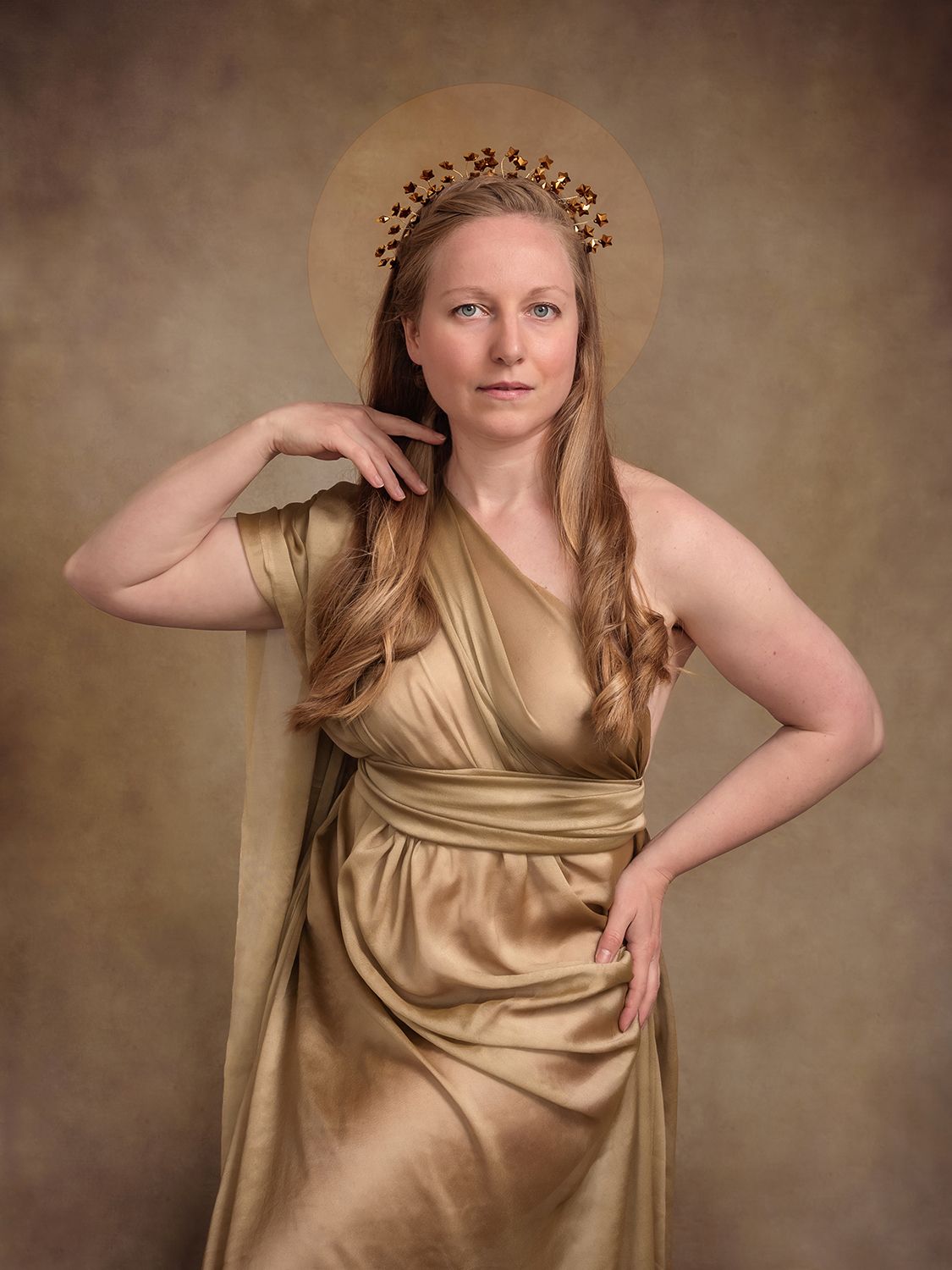 The photogrpher poses for a self portrait dressed in gold as a grecian goddess