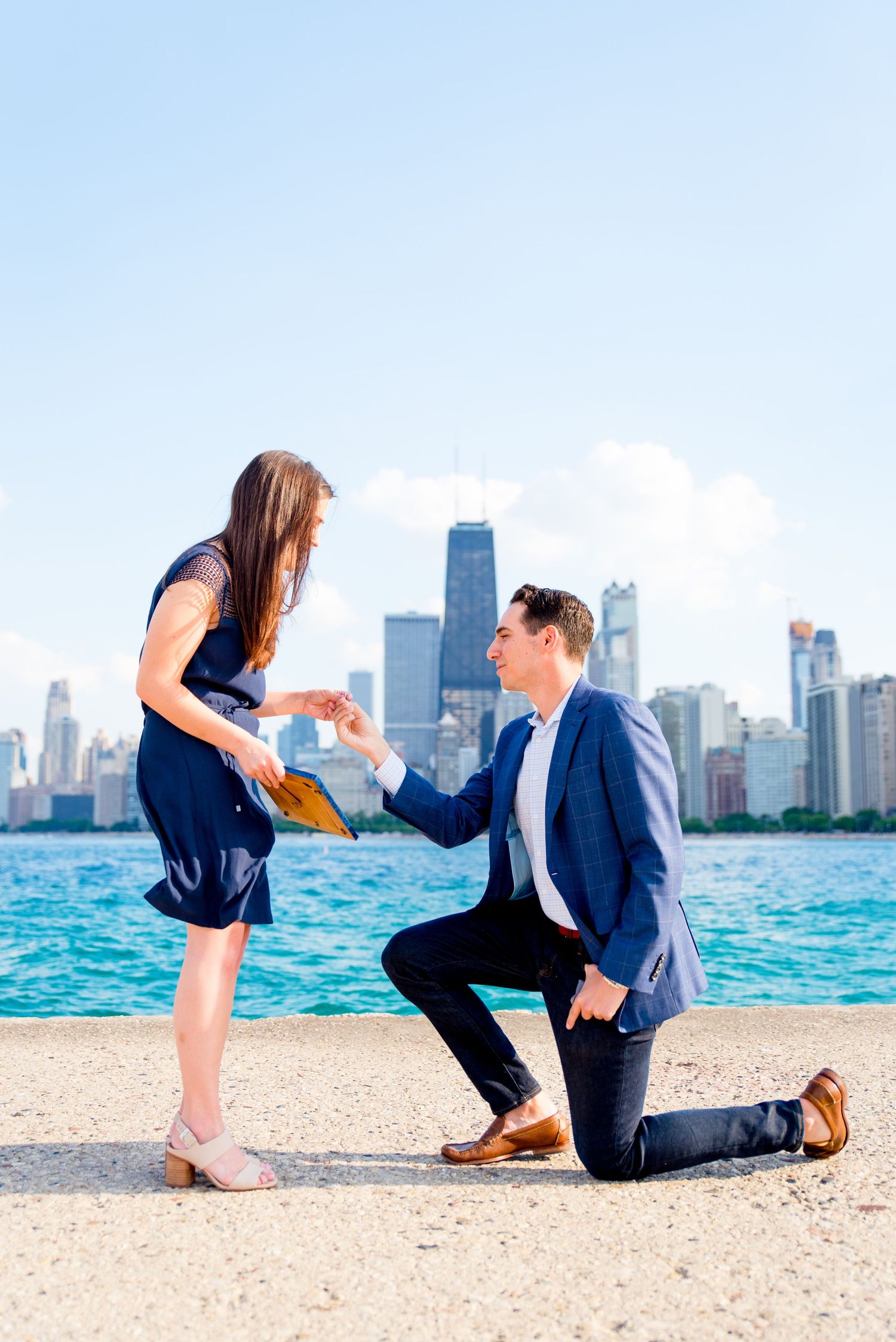 Man and woman holding hands during proposal at North Avenue beach