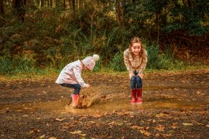 Children jumping in puddles during a Melbourne photoshoot