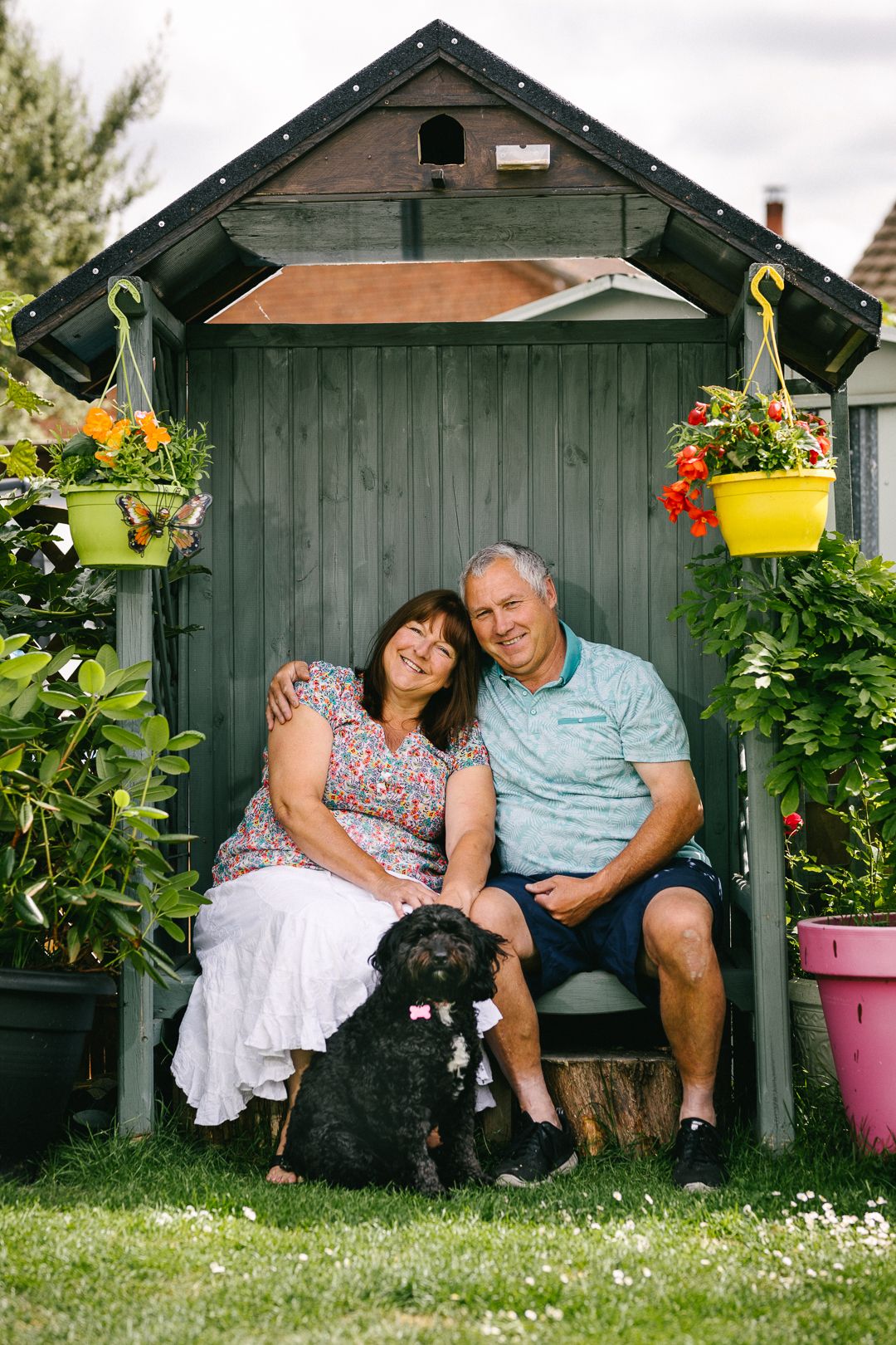 older couple on bench with their dog