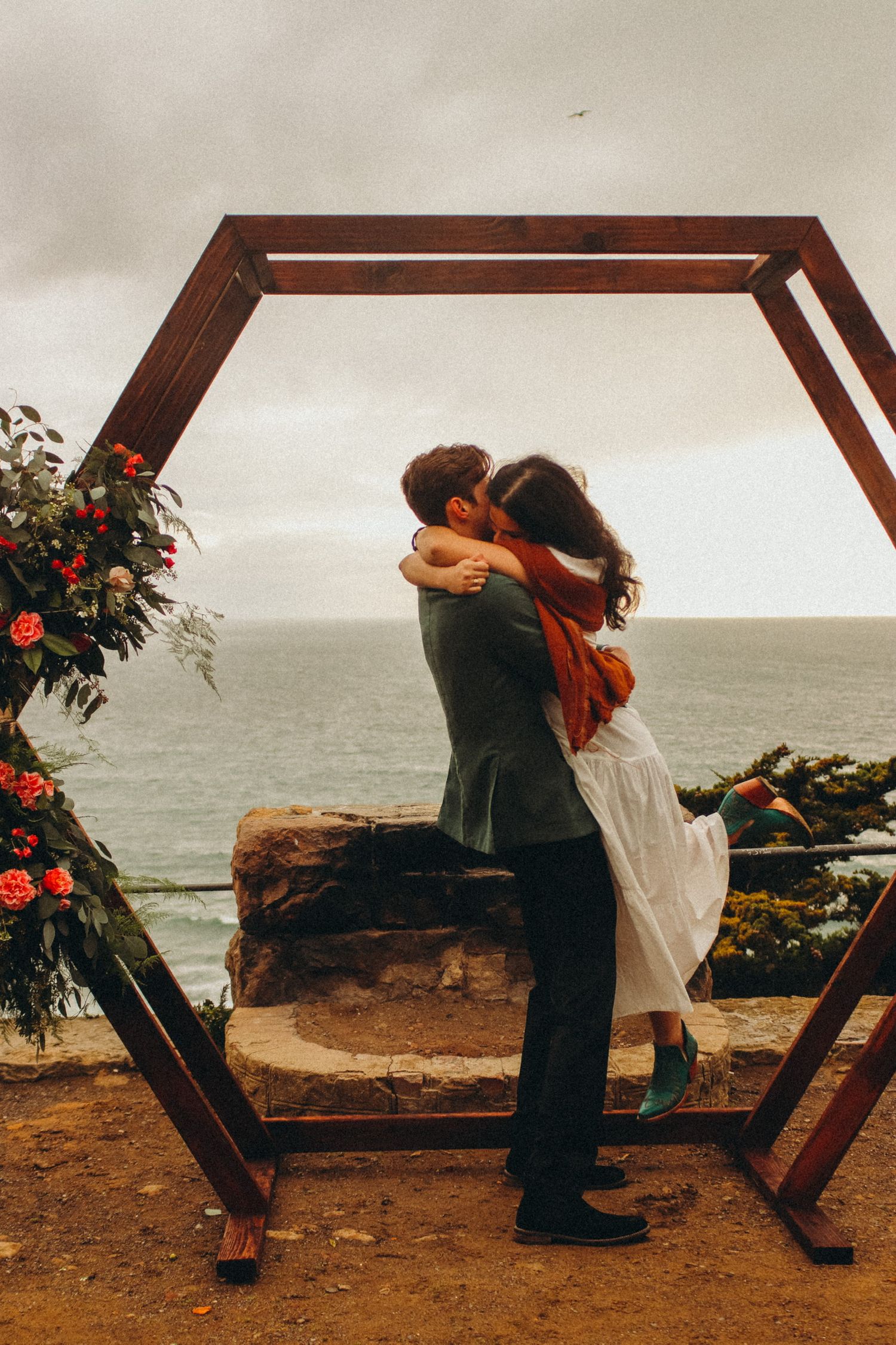 couple at wedding spinning after vows with wooden flower frame