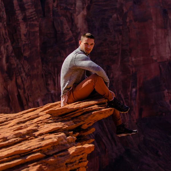 portrait of photographer skywalker zain sitting on a cliffs edge