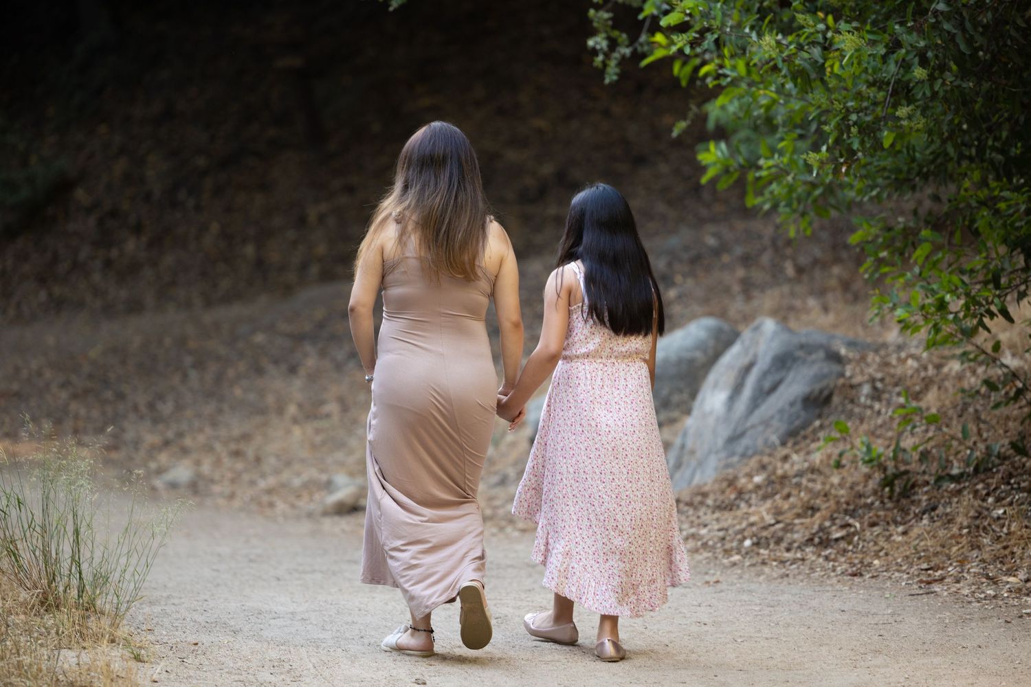 Mother and daughter holding hands while walking