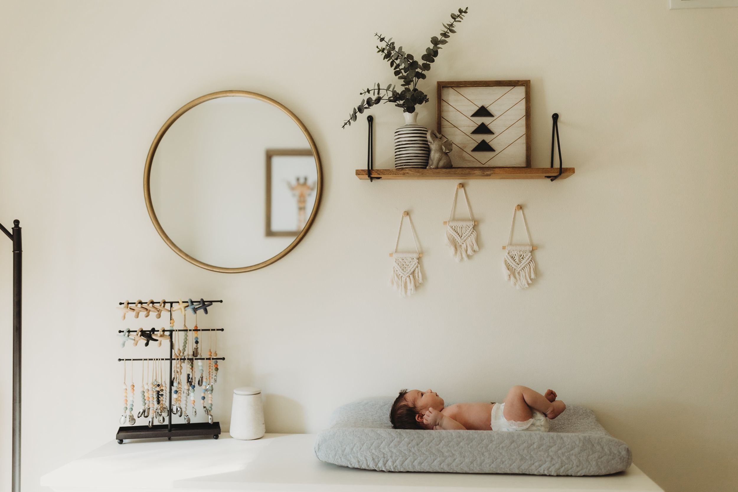 Newborn on changing pad in simple and neutral nursery. Photo by newborn photographer, Elizabeth Pachniak Photography.