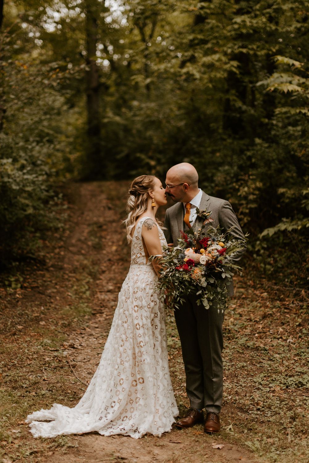 Bride and groom go in for a kiss in the woods at a Minneapolis park. Lindsay Miller Photography