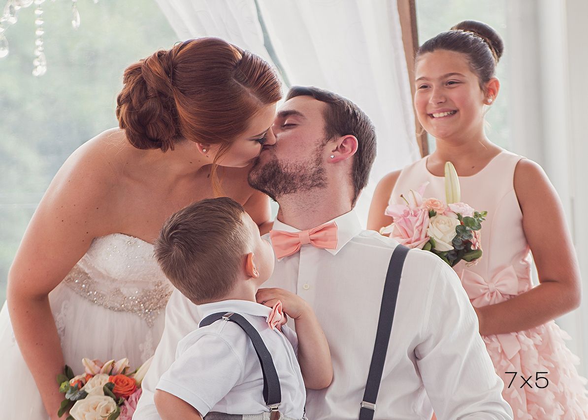 7x5 crop of bride and groom kissing while children look on