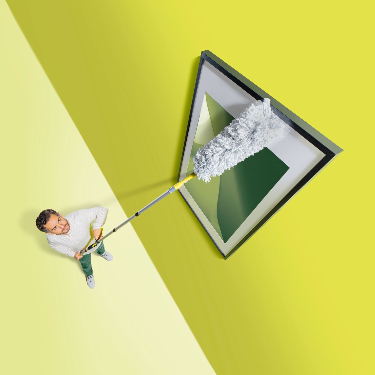 Conceptual cleaning image with extending duster reaching triangular frame on yellow-green background.