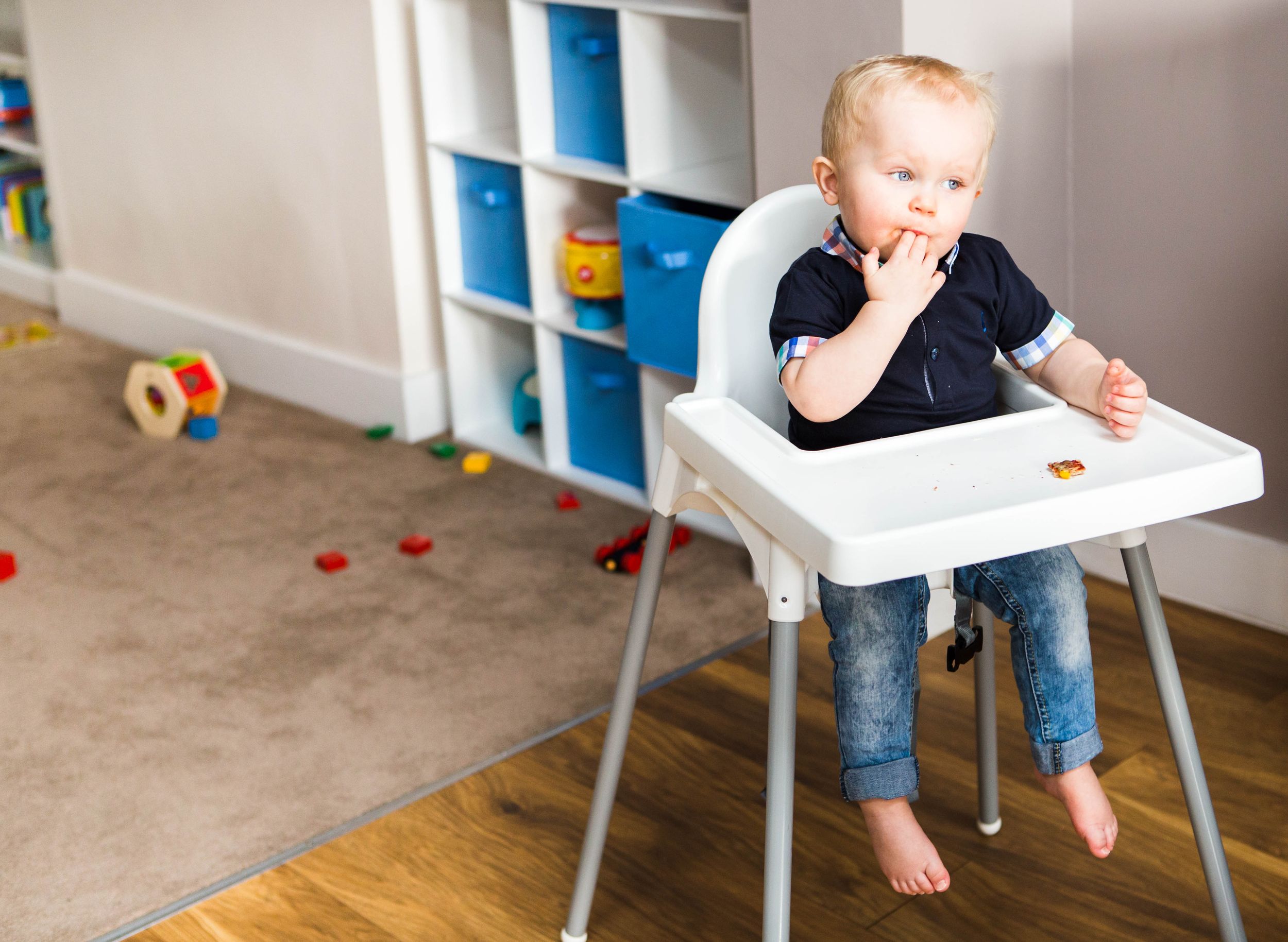 blonde toddler boy sitting in high chair