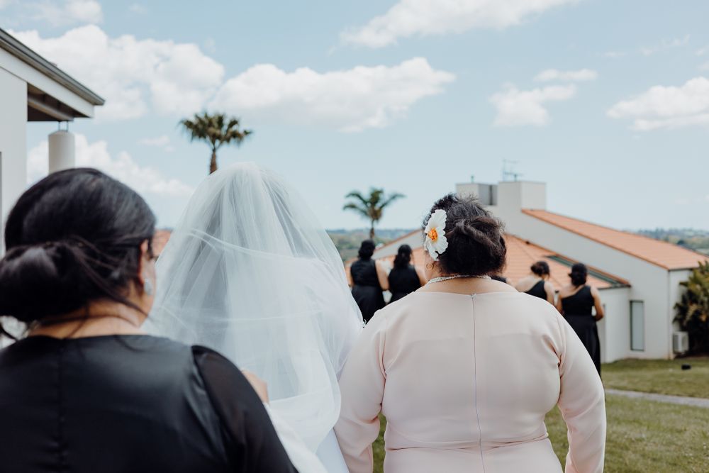 Wedding photography session taking place outside modern building with palm trees.