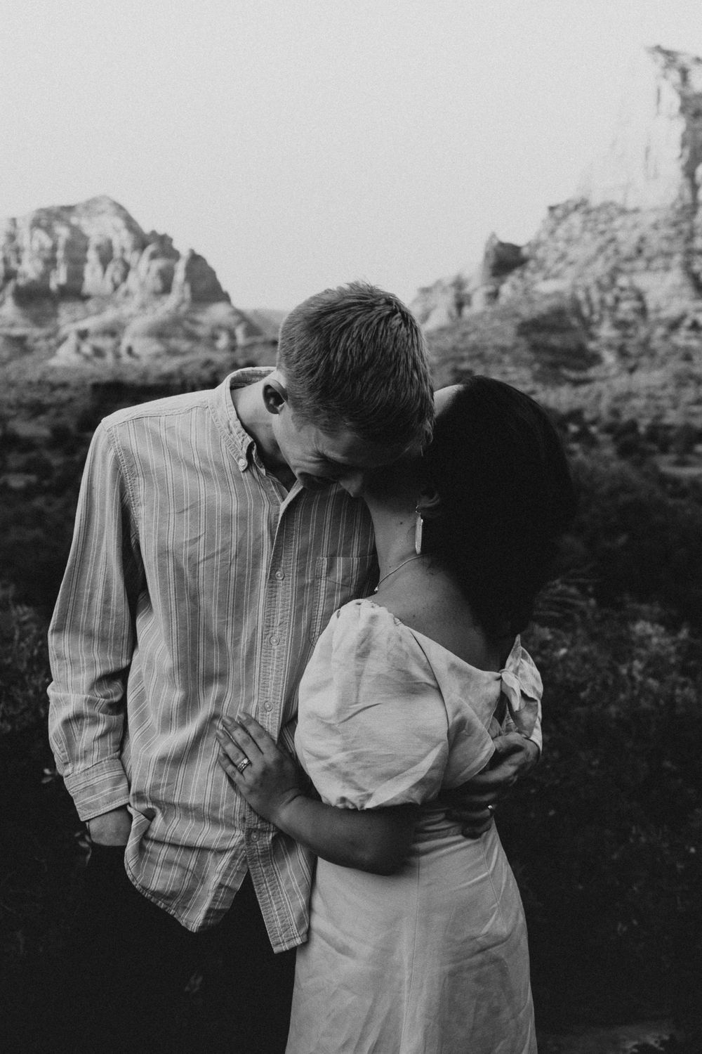 couple embracing as the woman whispers in the mans ear