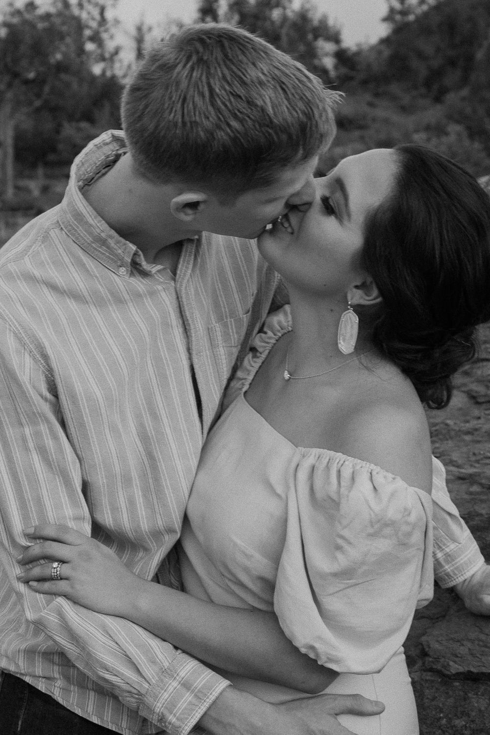 couple sharing a kiss with their arms around each other during their Sedona engagement session