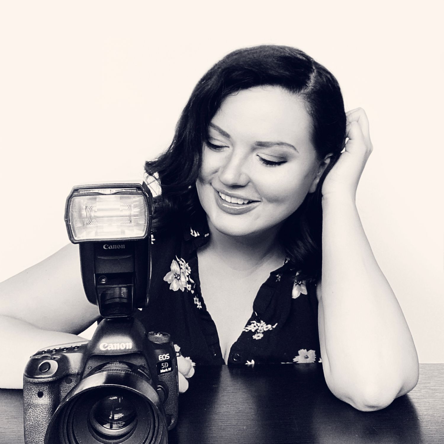 black and white image of photographer with camera smiling