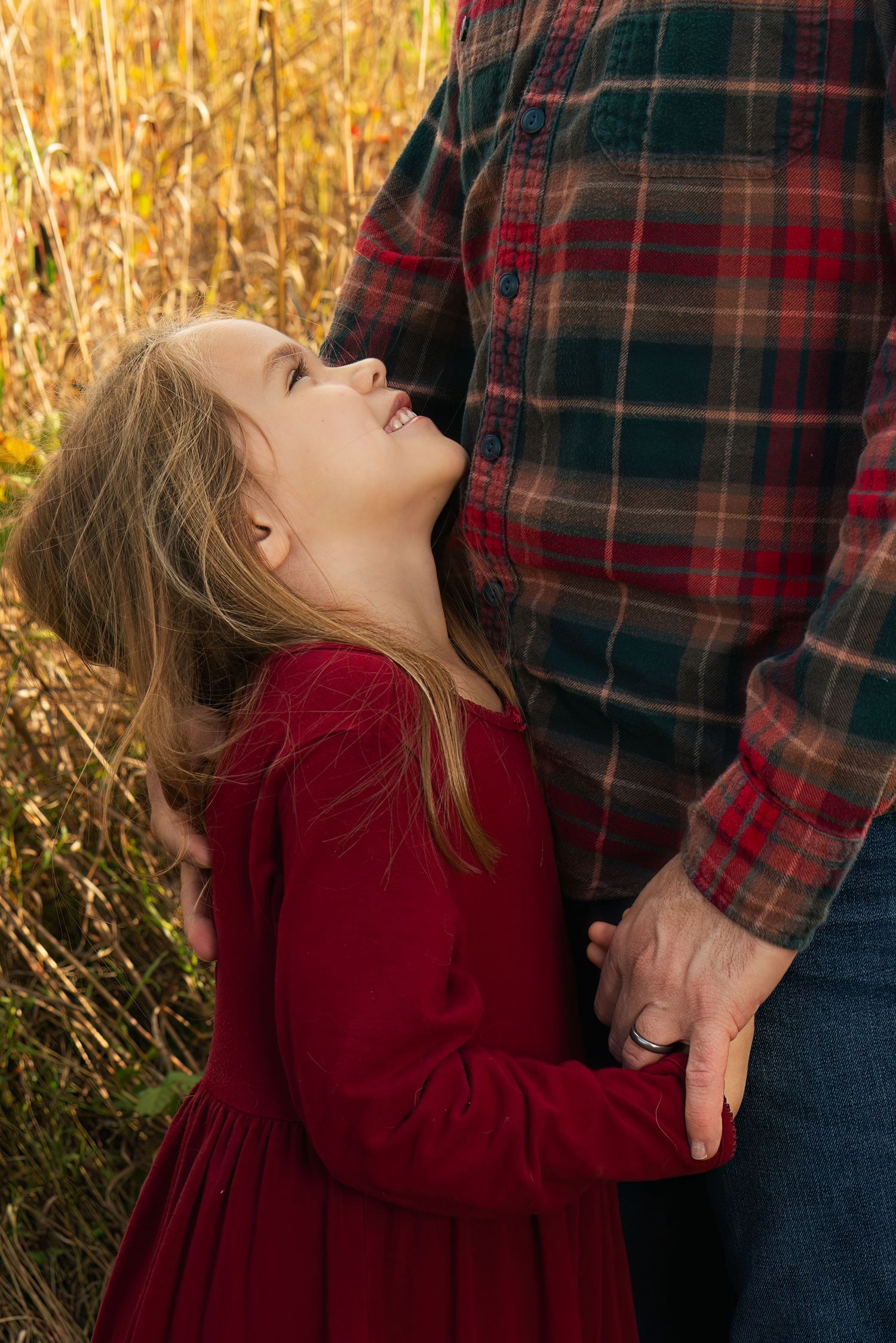 girl looks up at her daddy, who holds her hand