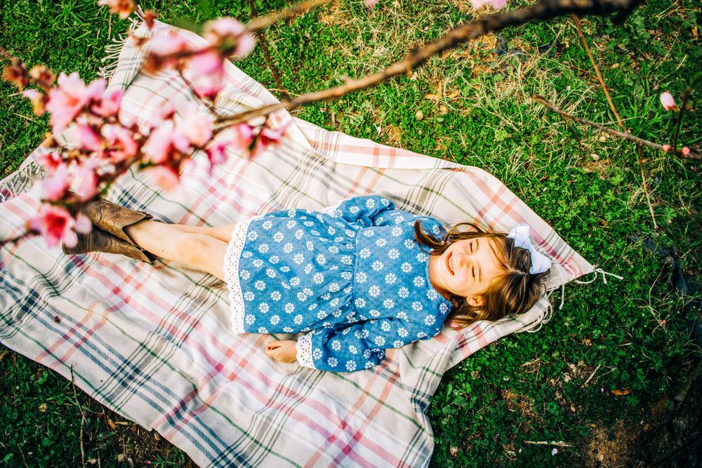 Little girl standing amongst the peach orchard blooms in Fort Mill, SC for a photo session