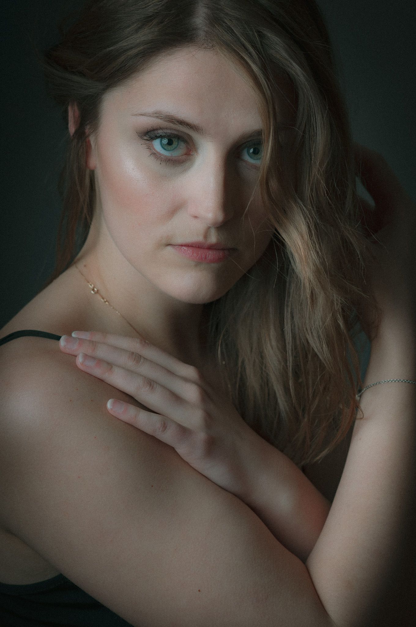 The moody lighting and dark background enhance the portrait’s dramatic and intimate feel.