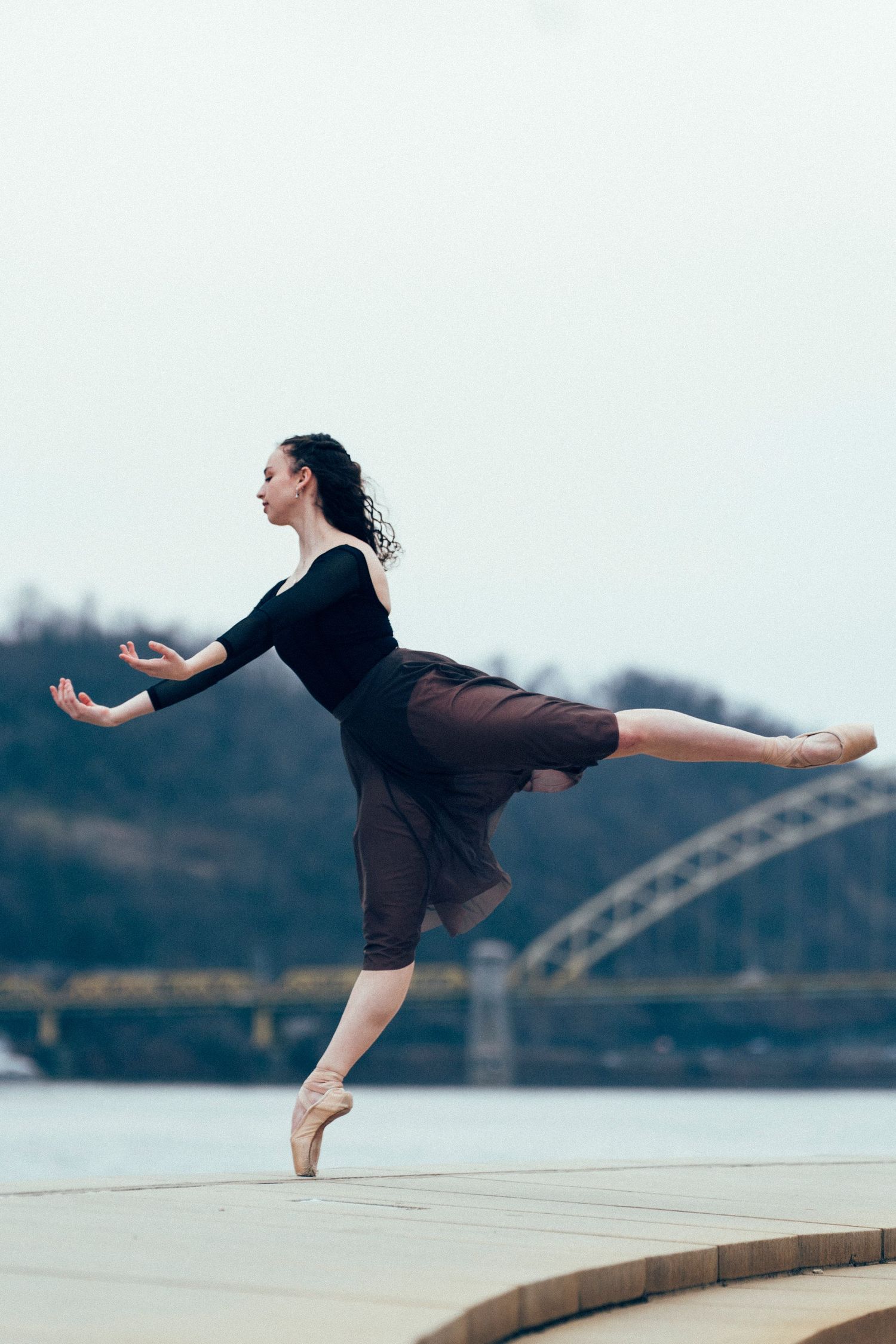 Ballet dancer posing under the warm glow of golden hour near the iconic Point State Park fountain pittsburgh dance photographer