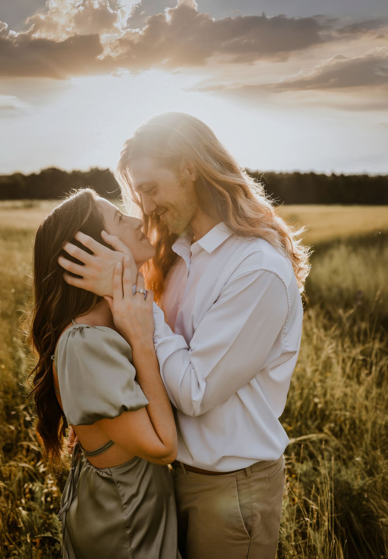 Close-up of engaged couple embracing with glowing field behind them