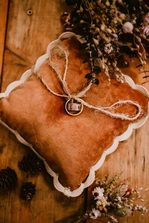 Pine cones and dried flowers arranged artistically on wooden background in warm sepia tones.